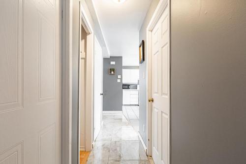 a hallway with white doors and a tile floor at Chez Joe - CITQ #3I74I4 in Terrebonne