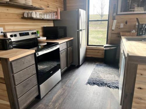 uma cozinha com um fogão e um frigorífico em Bourbon Barrel Cottages #1 of 5 on Kentucky trail em Lawrenceburg