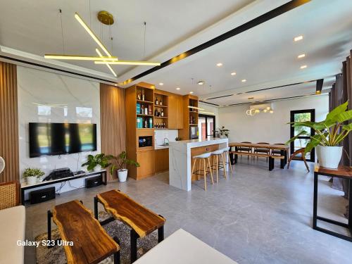 a living room with a table and chairs and a kitchen at Obra Maestro Private Resort in Lubao