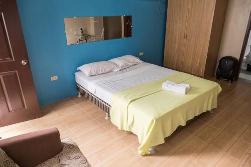 - une chambre avec un grand lit et un mur bleu dans l'établissement JW Apartments, à Ángeles