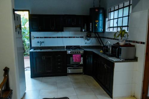 a kitchen with black cabinets and a stove top oven at Lo de Poujade in Posadas