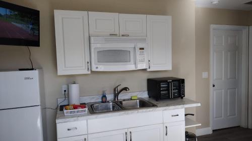 a kitchen with a sink and a microwave at The Orchard Suite of Sebring in Sebring