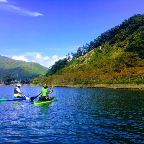 two people are kayaking on a lake at 静かに過ごす古民家ステイ Staying quietly in renovated house in Takashima