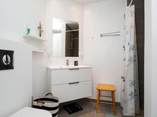 La salle de bains est pourvue d'un lavabo, d'un miroir et d'un tabouret. dans l'établissement Holiday home Gilleleje VII, à Gilleleje