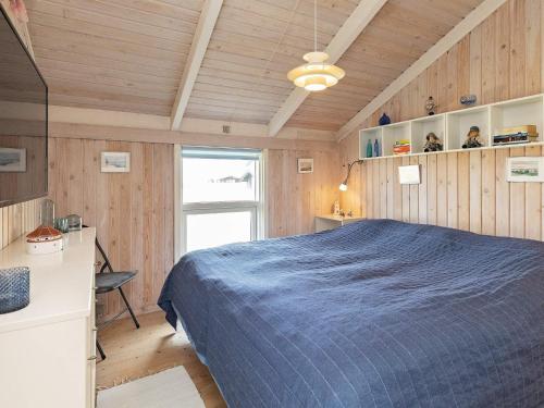 a bedroom with a bed and a desk and a window at 4 person holiday home in Hjørring in Hjørring