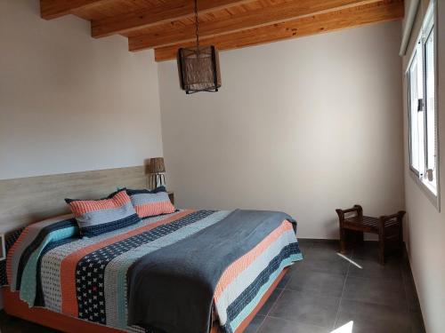 1 dormitorio con 1 cama en una habitación blanca en ALTOURQUIZA8 en Guaymallén