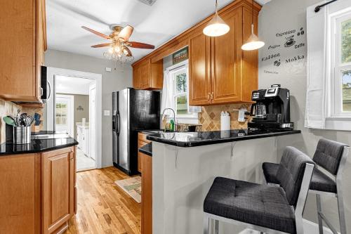 a kitchen with wooden cabinets and a black refrigerator at Orlando Oasis! Free Laundry & Parking Near Disney! in Orlando