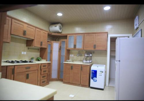 شقة جديدة ومفروشة للايجار اليومي والشهري في محافظة الرس في الرس: مطبخ بدولاب خشبي وثلاجة بيضاء