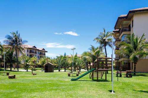 a playground with a slide in a park with palm trees at VG Sun Cumbuco Sea Breeze Vista Mar in Cumbuco