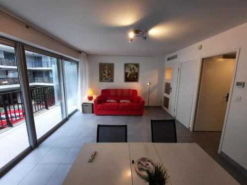 ein Wohnzimmer mit einem roten Sofa und einem Tisch in der Unterkunft Appartement Bayonne, 1 pièce, 2 personnes - FR-1-239-906 in Bayonne