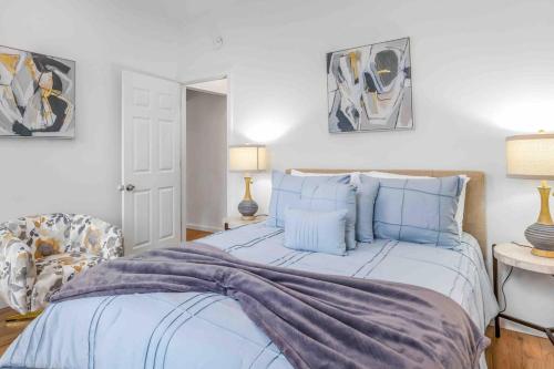 1 dormitorio con 1 cama grande con almohadas azules en Welcome to The Charming High st Suites, en West Chester