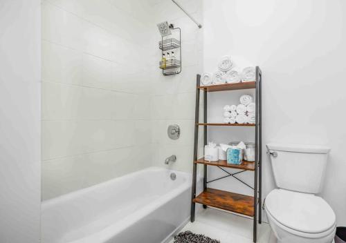 a bathroom with a white tub and a toilet at Welcome to The Charming High st Suites in West Chester