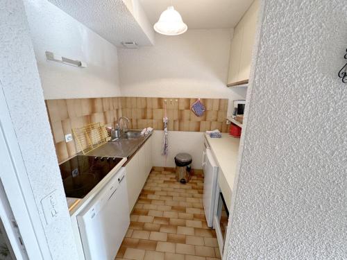 Il comprend une petite cuisine avec un évier et un comptoir. dans l'établissement Maison cosy à 300m de la plage du Fogeo, équipements modernes et parking privé - FR-1-639-91, à Arzon