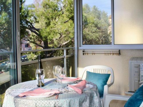 - une table avec une bouteille de vin et des verres sur un balcon dans l'établissement Studio climatisé, piscine & parking, proche plage - FR-1-252A-99, à Villeneuve-Loubet