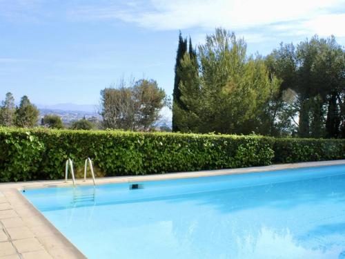 une piscine en face d'une haie dans l'établissement Appartement Villeneuve-Loubet, 1 pièce, 2 personnes - FR-1-252A-99, à Villeneuve-Loubet