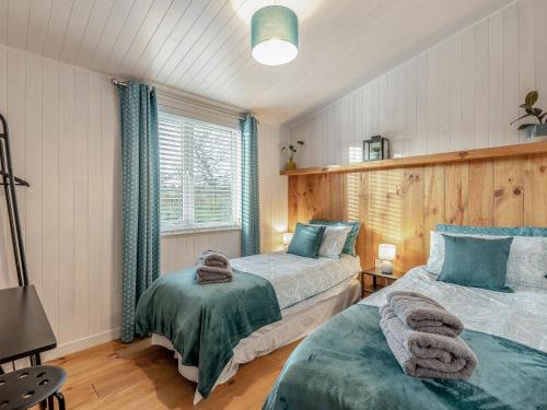 sypialnia z 2 łóżkami i oknem w obiekcie Heather Lodge w mieście Willington