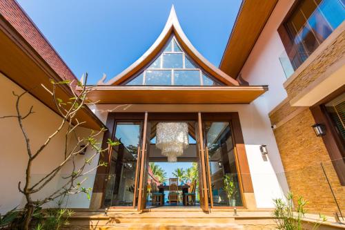an entry to a home with a chandelier at Baan Tao Talay - by Sublime Samui Villas in Lipa Noi