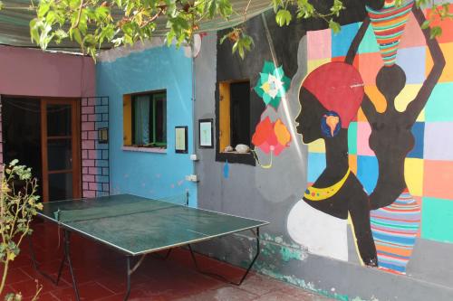 a room with a table and a painting on the wall at Hostel Posada de Gallo in Arica