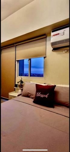 a bedroom with a large bed and a window at Field Residence SMDC 1BR w/ Netflix in Manila