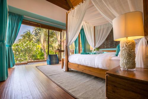a bedroom with a bed and a large window at Baan Tao Talay - Beachfront Private Villa in Lipa Noi