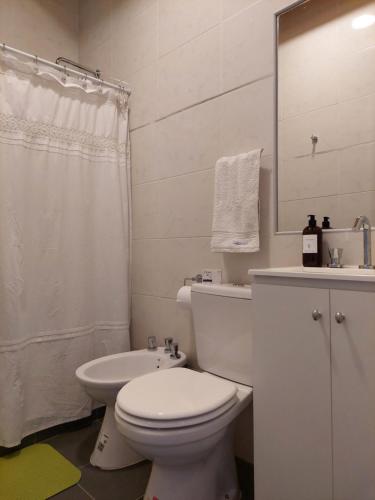 een witte badkamer met een toilet en een wastafel bij ALTOURQUIZA8 in Guaymallen