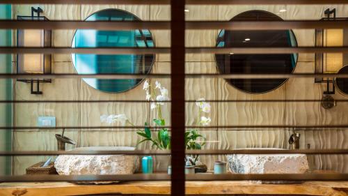a bathroom with two sinks and two mirrors at Baan Tao Talay - by Sublime Samui Villas in Lipa Noi