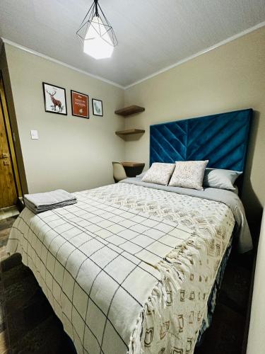 1 dormitorio con 1 cama grande y cabecero azul en Habitación cerca al aeropuerto el Dorado Bogota en Bogotá