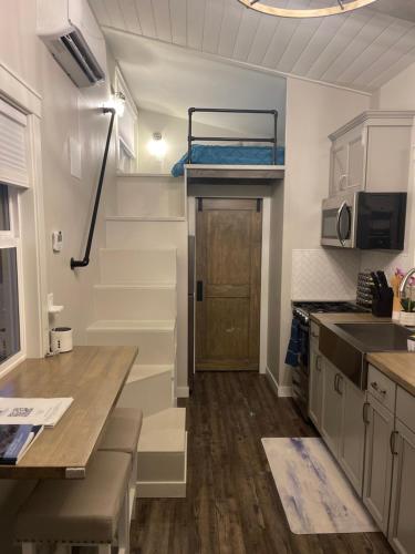 una pequeña cocina con una escalera en una casa pequeña en Delightful Tiny Home w/ 2 beds and indoor fireplace, en McKinleyville