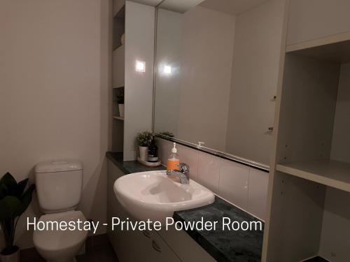a bathroom with a sink and a toilet and a mirror at Homestay - Yarra River Boulevard in Melbourne