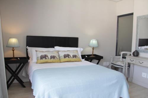 a bedroom with a large white bed with two lamps at Apt 67 Long Street no loadshedding in Cape Town