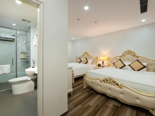 a large bedroom with two beds and a bathroom at Affa Boutique Hotel in Hanoi