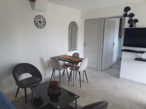 a living room with a dining room table and chairs at appartement in Marmande
