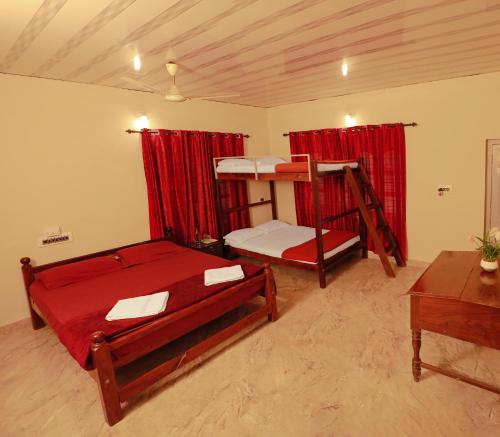 Kaniyāmbetta的住宿－Kudajadri Cottage，一间卧室设有两张双层床和一张桌子