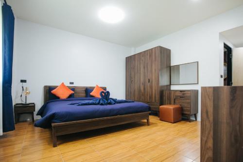 - une chambre avec un lit doté de draps bleus et d'oreillers orange dans l'établissement Baan Suan Wassana, à Buriram