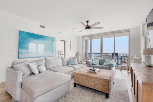 a living room with a couch and a ceiling fan at Emerald Dolphin unit 650 in Pensacola Beach