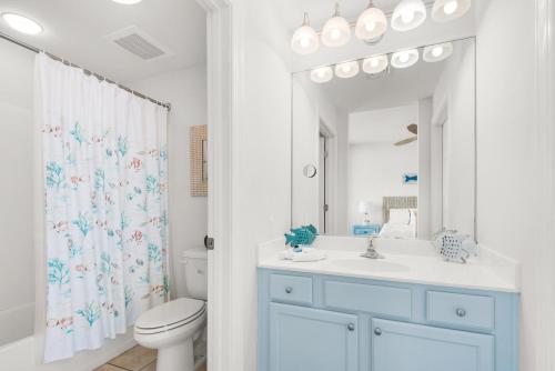 a bathroom with a toilet and a sink and a mirror at Emerald Dolphin unit 650 in Pensacola Beach