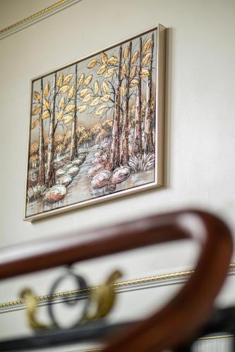 a painting hanging on a wall next to a chair at Affa Boutique Hotel in Hanoi