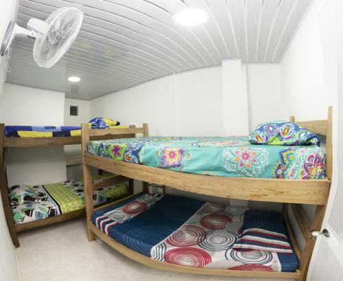 Zimmer mit 3 Etagenbetten und einem Ventilator in der Unterkunft Magic horizont in Taganga