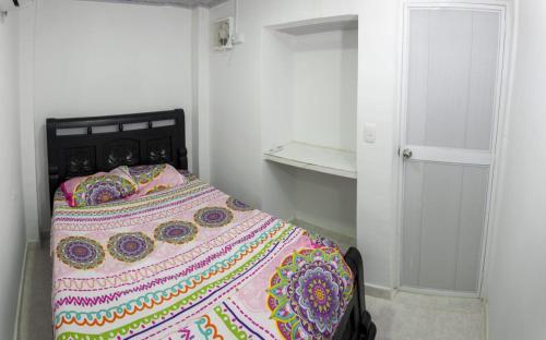 um quarto com uma cama com um cobertor colorido em Magic horizont em Taganga