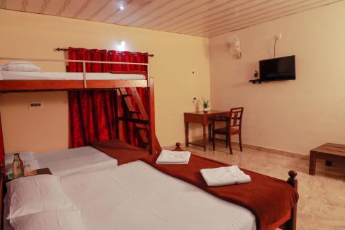 sypialnia z 2 łóżkami piętrowymi i biurkiem w obiekcie Kudajadri Cottage w mieście Kaniyāmbetta