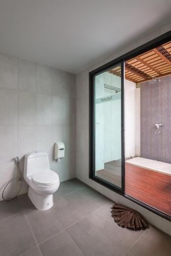 a bathroom with a toilet and a large window at Lanta Sand Resort & Spa in Ko Lanta