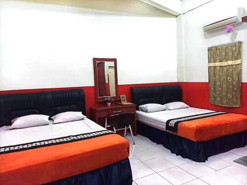 2 łóżka w pokoju z lustrem w obiekcie Hotel Al Madinah Bangkinang w mieście Bangkinang
