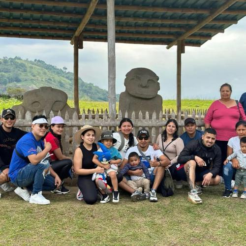 a group of people posing for a picture in front of a statue at Cabañas Guacari San Agustín huila in San Agustín