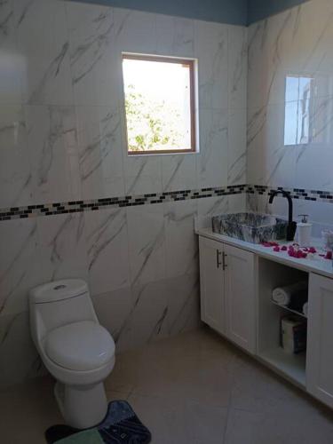 a bathroom with a toilet and a sink and a window at Desired View vacation rentals in LʼIvrogne