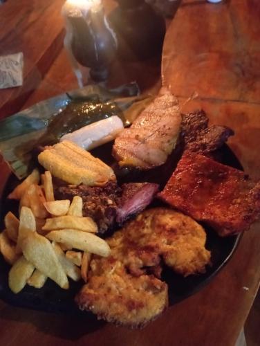 a plate of food with meat and french fries at Cabañas Guacari San Agustín huila in San Agustín