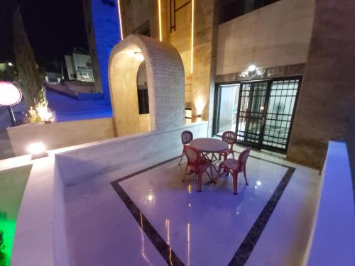 a patio with a table and chairs at night at شقق مرحبا المفروشة marhaba furnished apartment in Amman