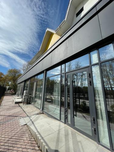 a building with glass doors on the side of it at Promenade Burabay halal-apartments (no alcohol, no unmarried couples)) in Borovoye