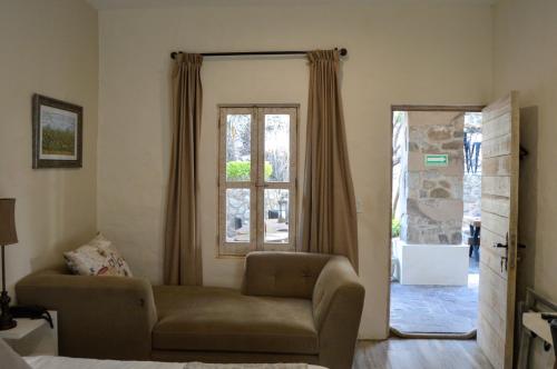 a living room with a couch and a window at Hotel de Piedra in Bernal