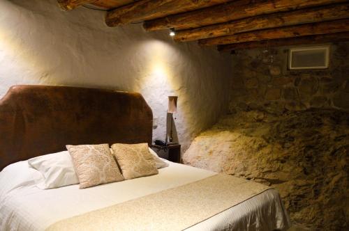 a bedroom with a bed in a stone wall at Hotel de Piedra in Bernal