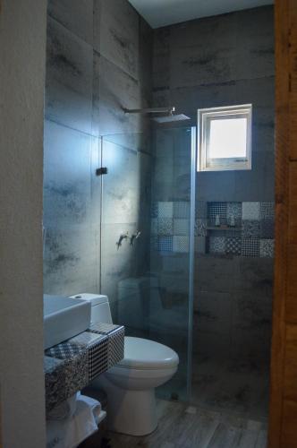 a bathroom with a toilet and a glass shower at Hotel de Piedra in Bernal